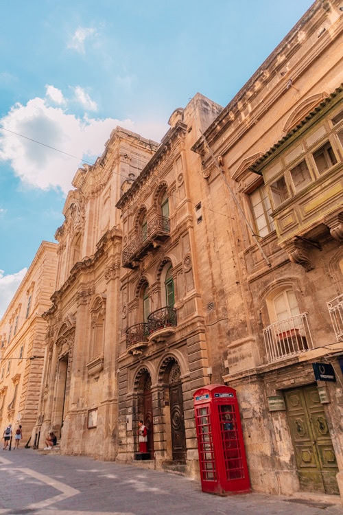 old building in the streets of Valletta Malta with a British red phone booth